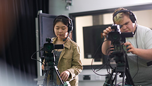 Two people running cameras