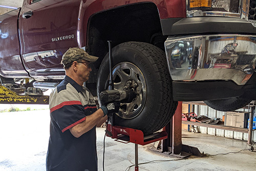 Butch changes a tire using his tire rotation assistance cart, provided by DVR.