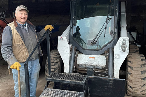 Scott Cebery uses steps and a handrail provided by DVR to safely board his Bobcat loader.