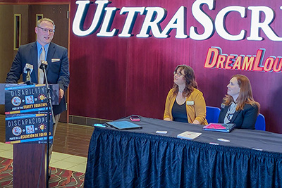 man speaking while two women look on