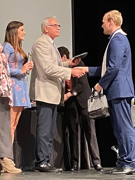 Christian Myers shakes hands with Stevens Point Area School District Superintendent Craig Gerlach while Project SEARCH Employment Coordinator Jemina Woods looks on with enthusiasm.