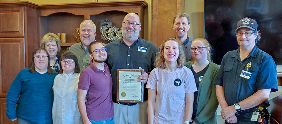 New Perspective Senior Living Executive Director Darin Duvall, center, was presented with the Exemplary Employer Award signed by Gov. Evers.