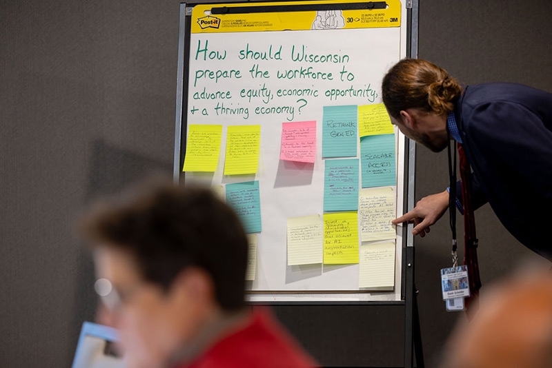 Kevin Schneider, senior training and development specialist at the Wisconsin Department of Administration, examines notes from a brainstorming session of the Equity and Economic Opportunity subcommittee during the inaugural meeting of the Governor's Task Force on Workforce and Artificial Intelligence on Monday, Oct. 30, 2023.