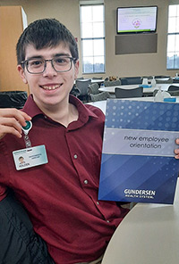 Holden Olstad holding new employee paperwork