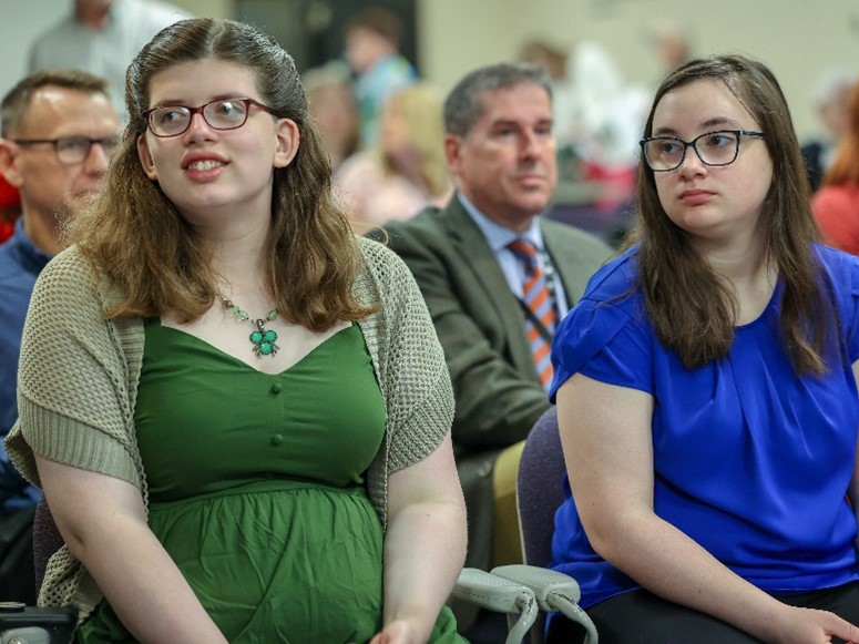 Elizabeth Wood and Isabella Theisen watch as more guests arrive as they patiently wait for the graduation ceremony to finally begin.