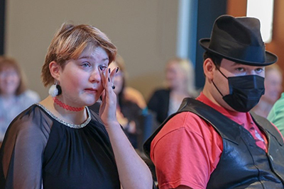Samantha Webb, seated next to Gabe Pozos, wipes a tear as she watches a slide show featuring photos from their Project SEARCH internship at Marquardt Village in Watertown